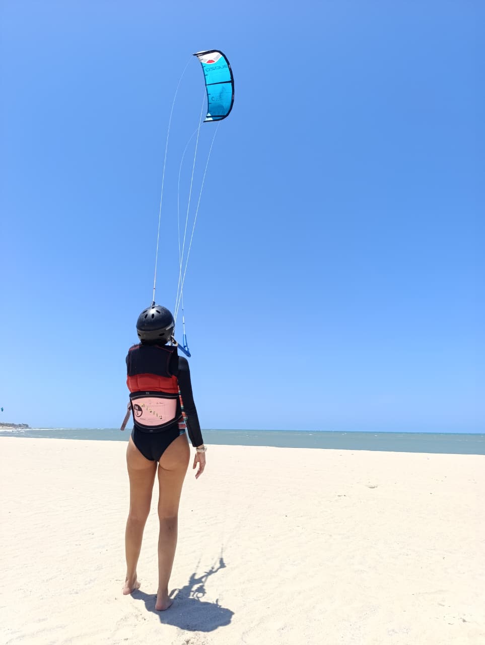 Aluna treinando o controle do kite na praia